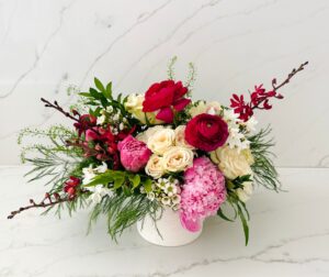 Pink, red and white floral arranged in a garden style in a premium ceramic vase