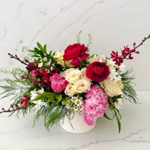 Pink, red and white floral arranged in a garden style in a premium ceramic vase